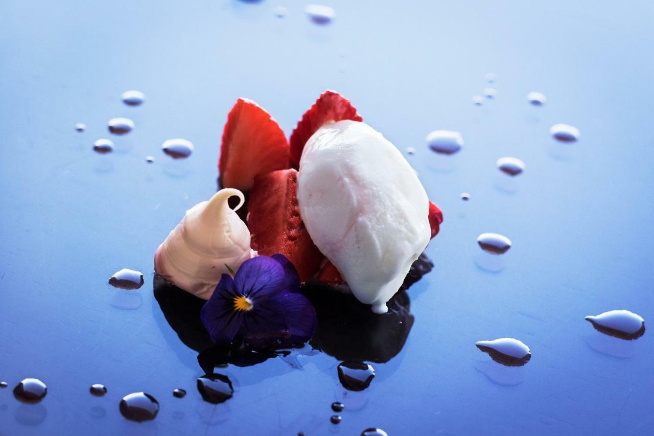 Eurostars Torre Sevilla Exterior foto The photo features an artistic presentation of dessert. It showcases several slices of fresh strawberries arranged neatly, accompanied by dollops of cream or mousse in a light color. Additionally, there is a scoop of what appears to be a light, cream
