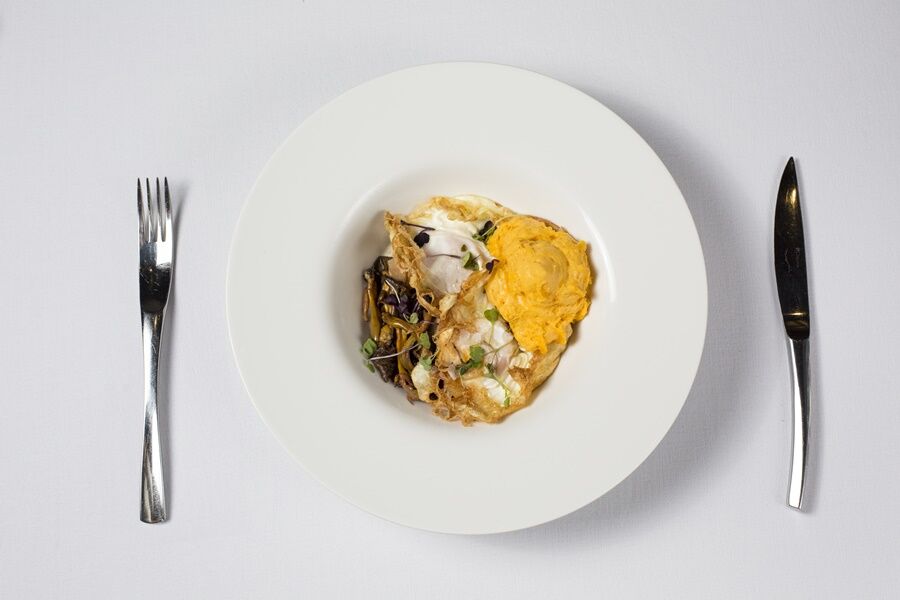 Eurostars Torre Sevilla Exterior foto The image features a white plate with a portion of food arranged in the center. The dish appears to include a mix of ingredients, possibly including a serving of fish or seafood, accompanied by a yellow component that may be a type of sauce or puree.